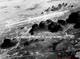 Runways among Karst peaks at the American base at Yangtong, Guilin, Guangxi province, China, during the Japanese occupation in late fall of 1944 until July 1945.  Bomb pits are visible in the runway in the foreground, which was blown up during the American evacuation to deny use to the incoming Japanese.