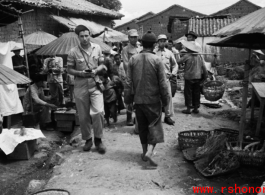 GI walking through market street at village near the American air base in WWII in Luliang, Yunnan province, China.