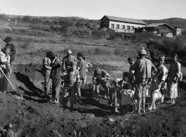Workers dig pit outside a beef slaughterhouse at Yangkai, set up specifically to provide meat for base personnel. During WWII.