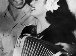 Celebrities visit and perform at Yangkai, Yunnan province, during WWII: Ruth Dennis poses with the accordion and a happy GI.