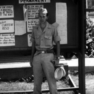 Henry Weiss of Brooklyn, NY; Tec 4, 219th Signal Depot Company, standing before a bulletin board at Tollygunge, India, during WWII.