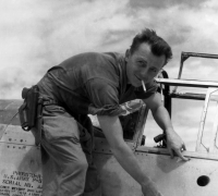 Henry E. Miehe, pointing to battle damage on his airplane. China, WWII.