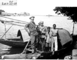 Two GIs on a boat with a family in India or Burma. During WWII.