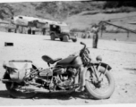 "Lt.Sohl took this cycle with him to every base we serviced. I had never ridden a cycle before and he let me ride it around the revetment one day and I ended up driving right thru the door of the engineering shack and pinned "Rocky" Taurisano against the back wall of the shack. That was the first and last time I ever rode a cycle." Caption courtesy of Elmer Bukey.
