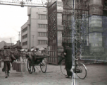 A city gate in Kunming city, Yunnan province, China, during WWII, with a Nationalist soldier riding a rickshaw. 