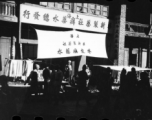 A large sign advertises for psoriasis lotion (牛皮癣水), and touts call out to passers-by in China. During WWII.  From the collection of Hal Geer.