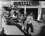 Men tote a decorated sedan chair used to carry the bride during weddings. In China, during WWII.