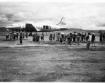 Local laborers working on construction of airbase at Luliang, China, with a C-54 transport in background. During WWII.