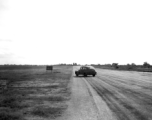 Car on a runway, probably in India or Ceylon, during WWII.
