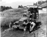 T/5 Theodore E. Eitel directs children in cleaning his Burma Road Engineers truck, after a day of hauling rock for the Kao Tien district of the Burma Road being built from Lungling, China, to meet the Ledo Road at the Burma border.  Yunnan Province on December 1, 1944.   Photo by T/Sgt. Greenberg. B-Detachment, 164th Signal Photographic Company, APO 627.  Passed by William E. Whitten.