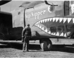 Selig Seidler, camera in hand, standing before the B-24 "Nip Nipper" somewhere in China during WWII.