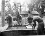 GIs of 797th Engineer Forestry Company washing their eating utensils in Burma.  During WWII.