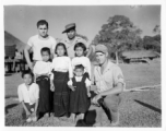 Local people in Burma near the 797th Engineer Forestry Company--GIs pose with local Kachin man and several children in a village.  During WWII.