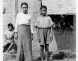 Local people in Burma near the 797th Engineer Forestry Company--girl and boy, apparently stand in front of missionary school.  During WWII.