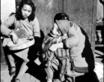 Local people in China go about their daily lives in China at roadside. During WWII.