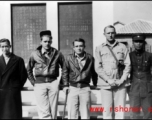 American air men who survived an air incident, with some of the Chinese men who took care of them on the ground. During WWII, in China.  The plaque on the back is commemorating the construction of a local fortress ("青年堡垒").