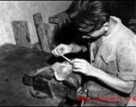 A Chinese worker repairs a piston by hand at an American base in China during WWII.