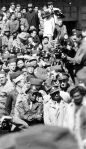 Note movie camera filming on far right, and just below that, a couple of African-American officers.