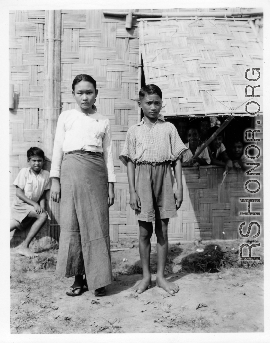 Local people in Burma near the 797th Engineer Forestry Company--girl and boy, apparently stand in front of missionary school.  During WWII.