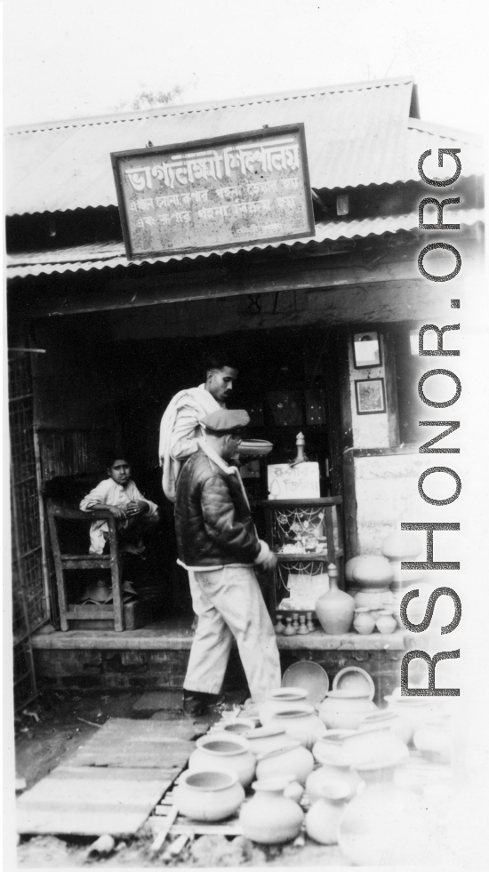 GI shops at a small shop.   Scenes in India witnessed by American GIs during WWII. For many Americans of that era, with their limited experience traveling, the everyday sights and sounds overseas were new, intriguing, and photo worthy.