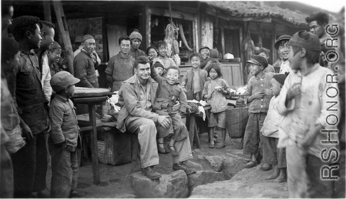 At a hardware stand, GI Fred Nash, with appreciative local people. Yangkai Village, Spring 1945.