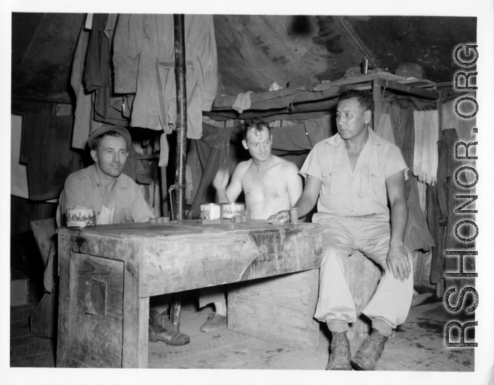 Engineers of the 797th Engineer Forestry Company pose in their tent in Burma, with checker pieces.  During WWII.