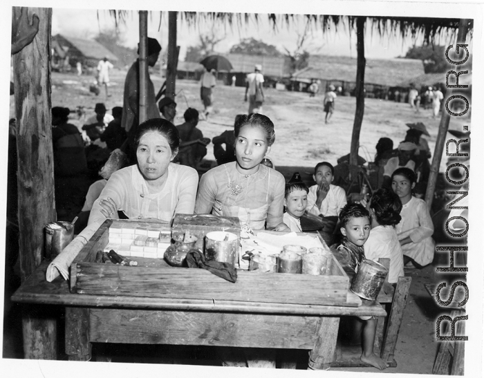 Ladies vending cigars, cigarettes, white face powder, etc., at an activity in Burma.  In Burma near the 797th Engineer Forestry Company.  During WWII.