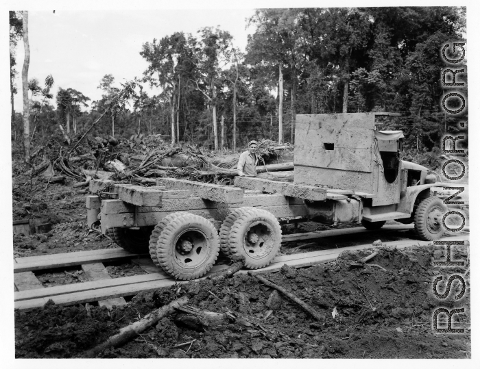 797th Engineer Forestry Company in Burma, truck backs up for loading logs for transport to sawmill for bridge building along the Burma Road.  During WWII.