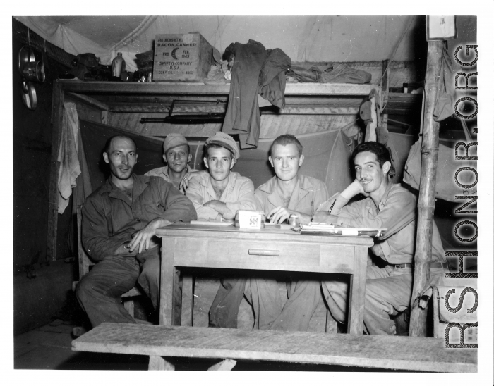 Engineers of the 797th Engineer Forestry Company pose in their barracks in Burma. Note the canned bacon on the shelf behind.  During WWII.