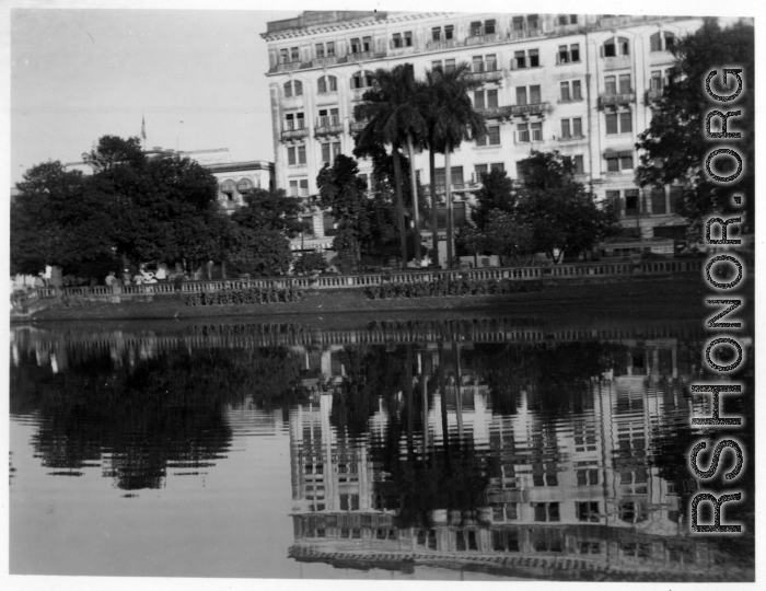 Large building and waterway in city.  Scenes in India witnessed by American GIs during WWII. For many Americans of that era, with their limited experience traveling, the everyday sights and sounds overseas were new, intriguing, and photo worthy.