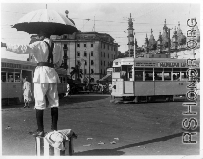 Traffic policeman directs traffic as trams go by.  Scenes in India witnessed by American GIs during WWII. For many Americans of that era, with their limited experience traveling, the everyday sights and sounds overseas were new, intriguing, and photo worthy.