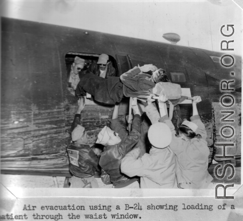 Air evacuation using a B-24 showing loading of a patient through the waist window.