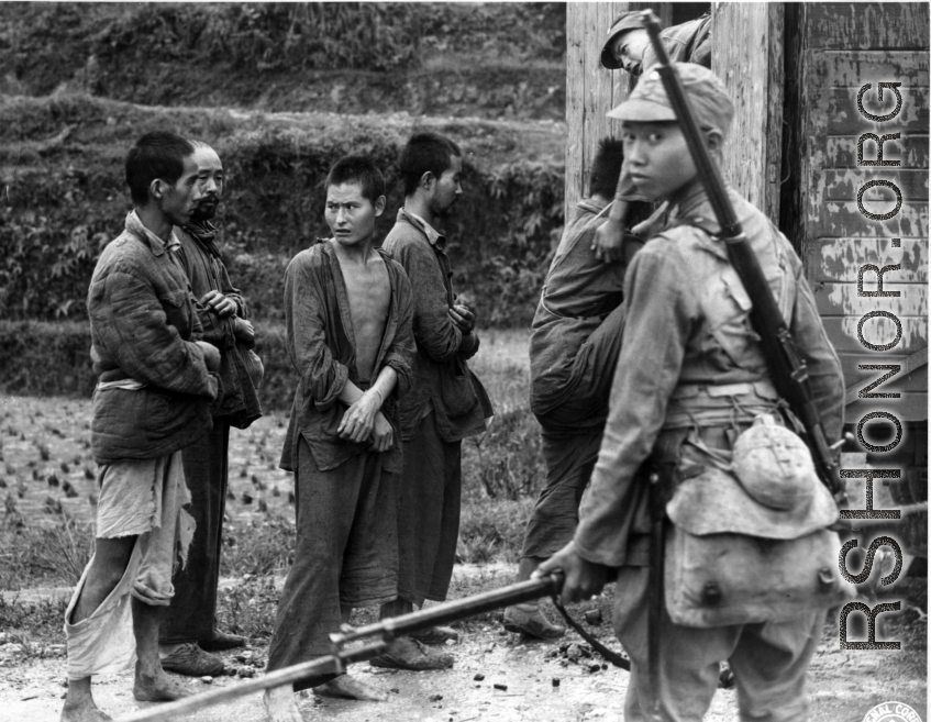 Conscripts being loaded onto transport, or Japanese prisoners being loaded. In China during WWII.