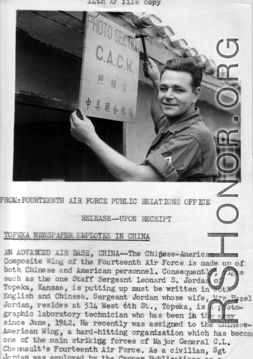 Leonard S. Jordan of the Chinese-American Composite Wing (CACW) hangs a sign indicating the "Photo Section," in both English and Chinese.  照相室，中美联合大队。