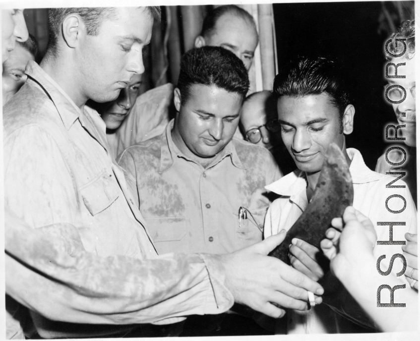 Men examine what is presumably a knife of some kind, in the CBI during WWII.