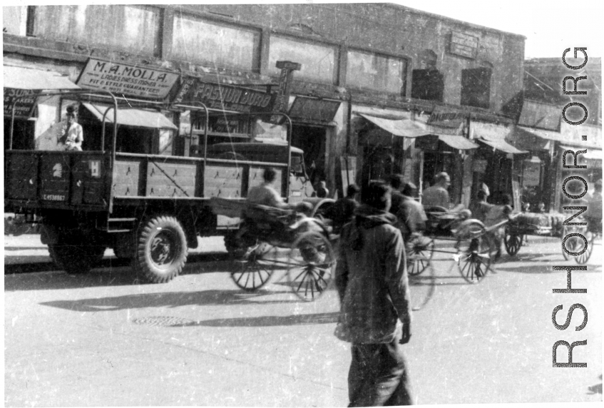 Street in India or Burma, with GIs riding rickshaws. During WWII.