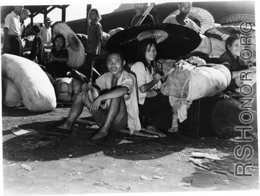 Chinese refugees shelter from the hot sun under paper umbrellas at the train station in Liuzhou during WWII, in the fall of 1944, as the Japanese advanced during the Ichigo campaign.