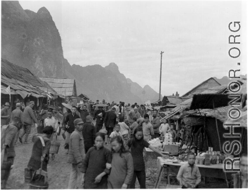 Bustling street scene of Chinese civilians and Nationalist soldiers not far from the south side of the floating bridge at Liuzhou, near the American air base, around the time of the evacuation of fall 1944.