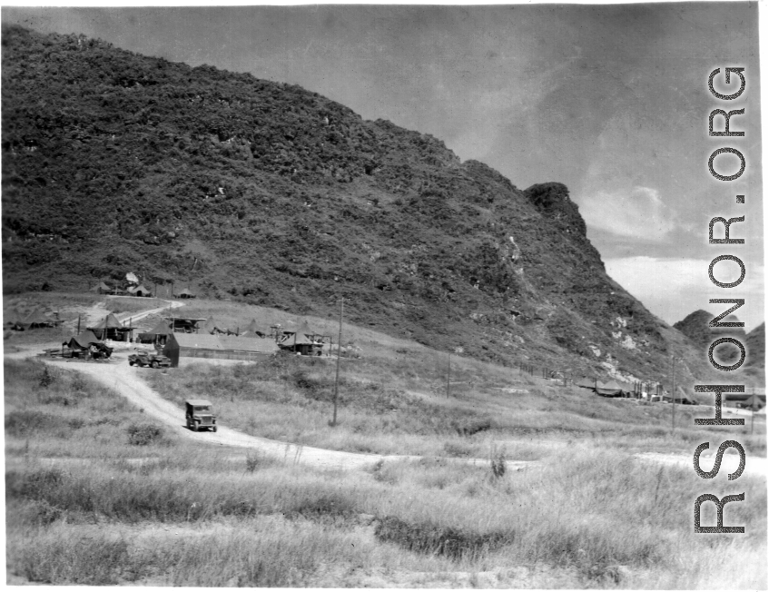 A jeep comes down from a cluster of tents and workshops at Liuzhou during WWII, in 1945.