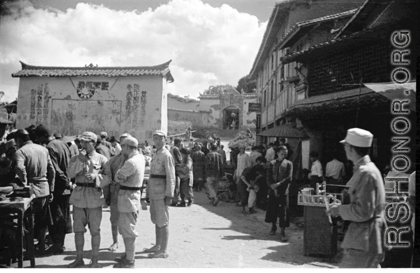 Market At Luliang, China, not far from American base, during WWII. Note the Nationalist propaganda on the facing wall.