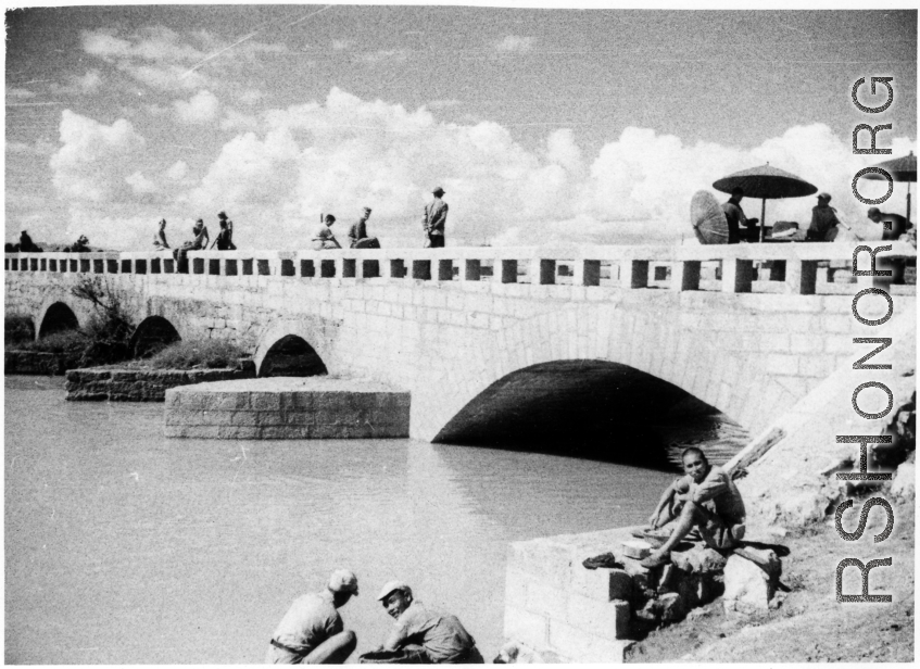Nationalist soldiers (plus possibly one GI) lounge on the bridge at Luliang. During WWII.