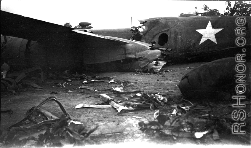 Wrecked B-25 Mitchell bomber on the ground in the CBI. The wreck was apparently at an air base, and probably on take-off, as the craft is sprayed with fire-retardant foam, and bombs are scattered about the wreck site. During WWII.