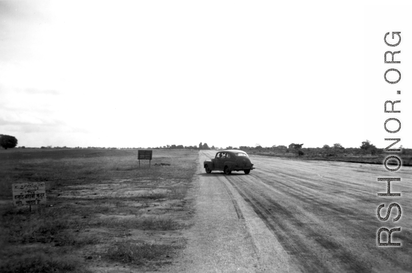 Car on a runway, probably in India or Ceylon, during WWII.