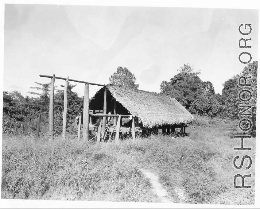 A woman in a thatch house on stilts in Burma.  Near the 797th Engineer Forestry Company.  During WWII.