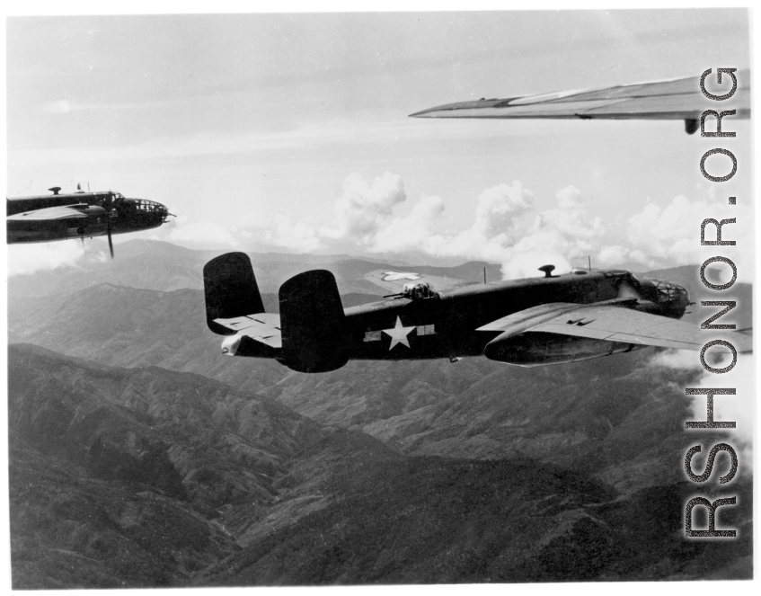 B-25s of the 22nd Bombardment Squadron in flight over rough mountains of SW China or Burma during WWII.