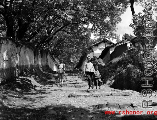 Local people in China: Villagers in Yunnan walk a village path.  From the collection of Eugene T. Wozniak.
