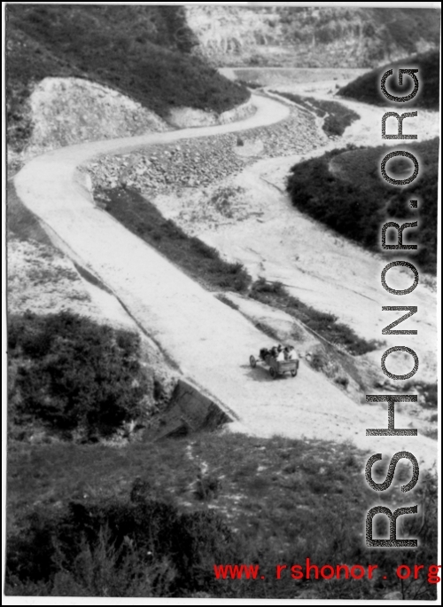 A vehicle passes along a newly cut road in SW China during WWII.