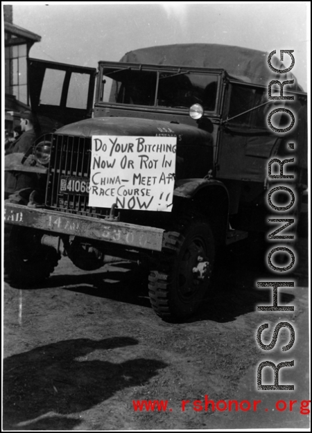 American truck with a sign advertising meeting at race course in the CBI during WWII.