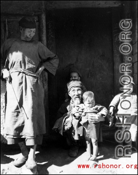 Village elders holds child in Yangkai village.  From the collection of Frank Bates.