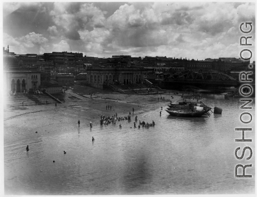 Fancy buildings alongside a river.  Scenes in India witnessed by American GIs during WWII. For many Americans of that era, with their limited experience traveling, the everyday sights and sounds overseas were new, intriguing, and photo worthy.